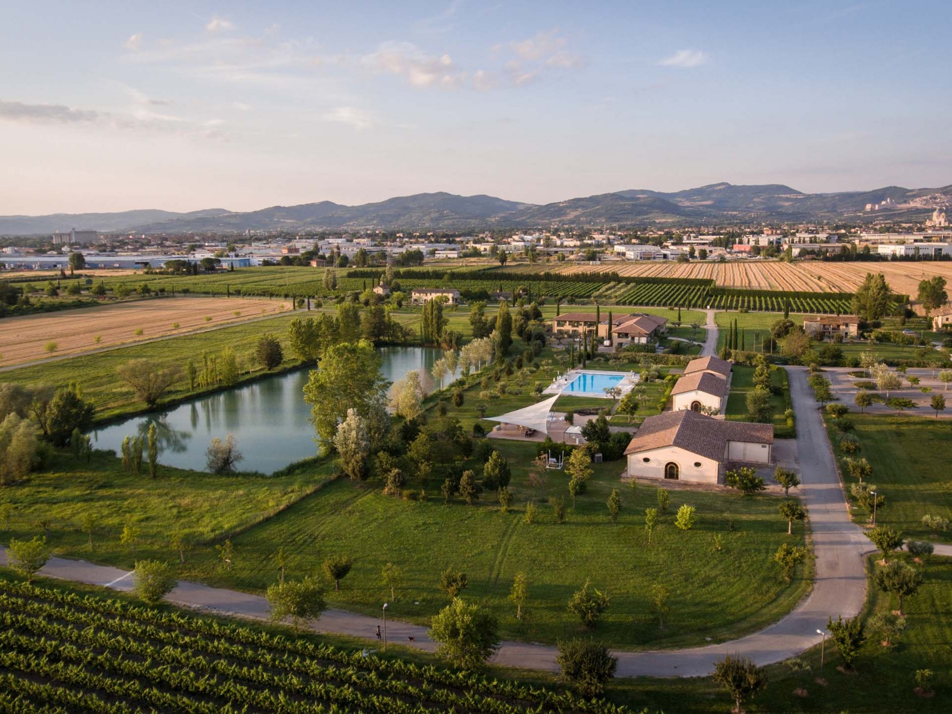 Deluxe room Aerial view of a farmhouse with pool, pond, and cultivated fields