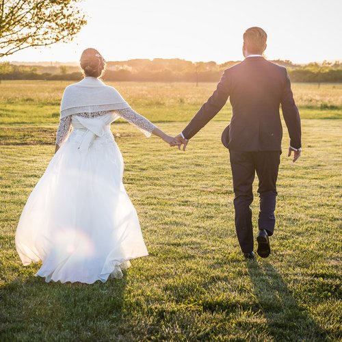 La missione di Valle di Assisi Coppia di sposi che camminano tenendosi per mano in un prato al tramonto