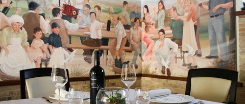 Deluxe room Set table with wine in front of mural showing people celebrating