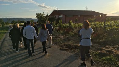 Resort Hotel Assisi com Padel Tennis Bike Hotel 3 swimming pools soccer field. Group of people walking on a road near a rural house at sunset