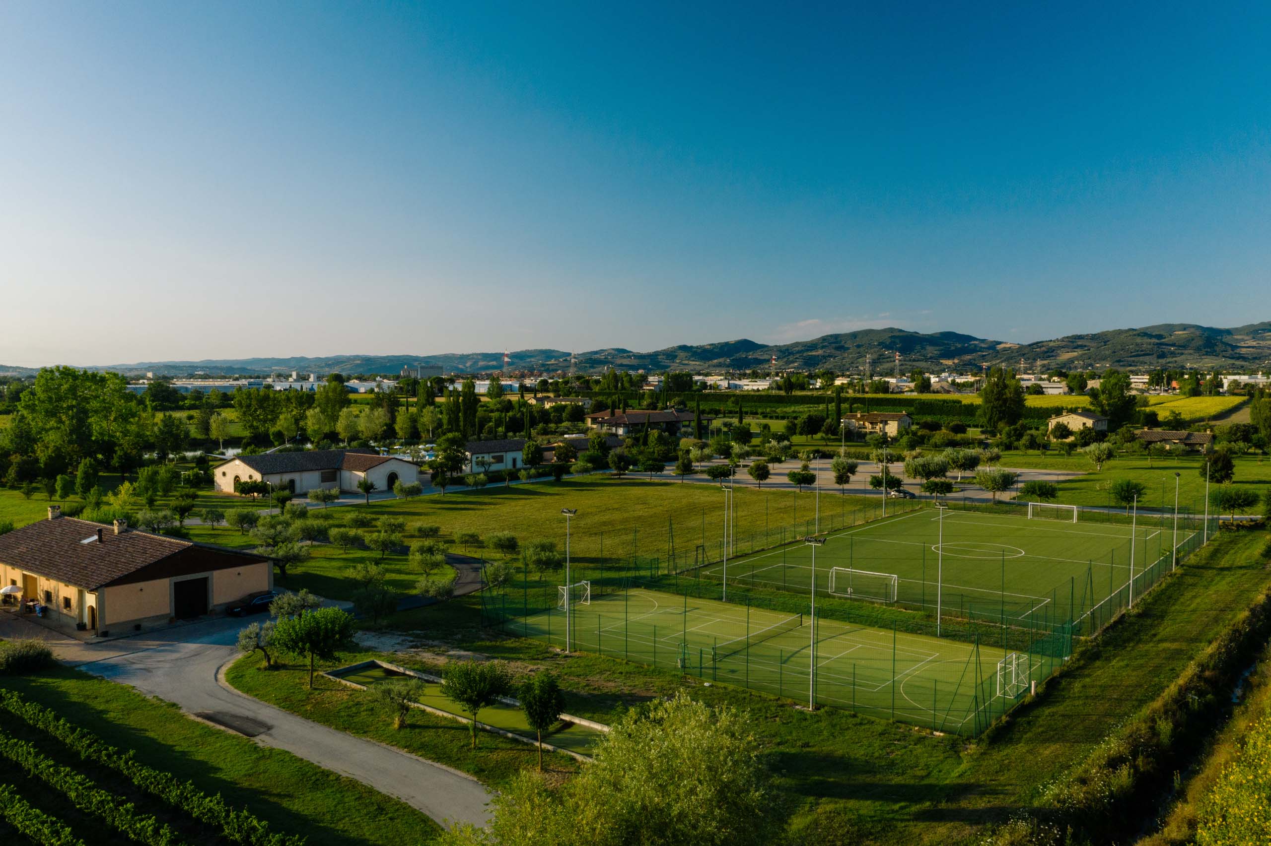 La missione di Valle di Assisi Campi sportivi in un'area verde con montagne sullo sfondo